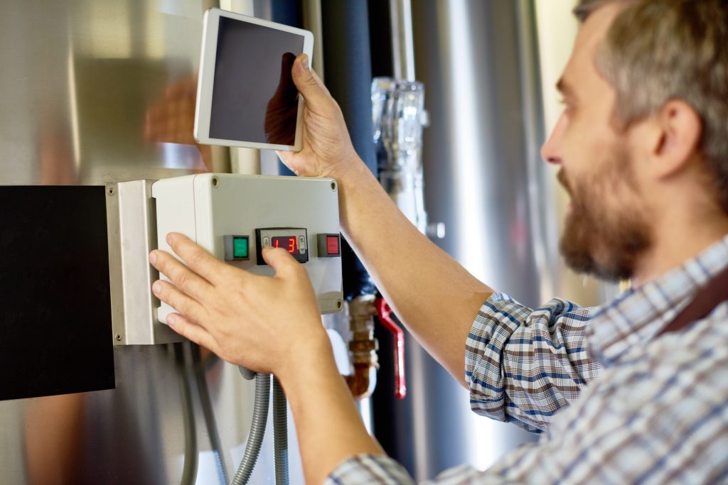 Brewing technician setting up equipment at factory
